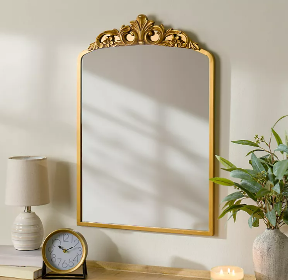 Round wall mirror with gold frame above console table